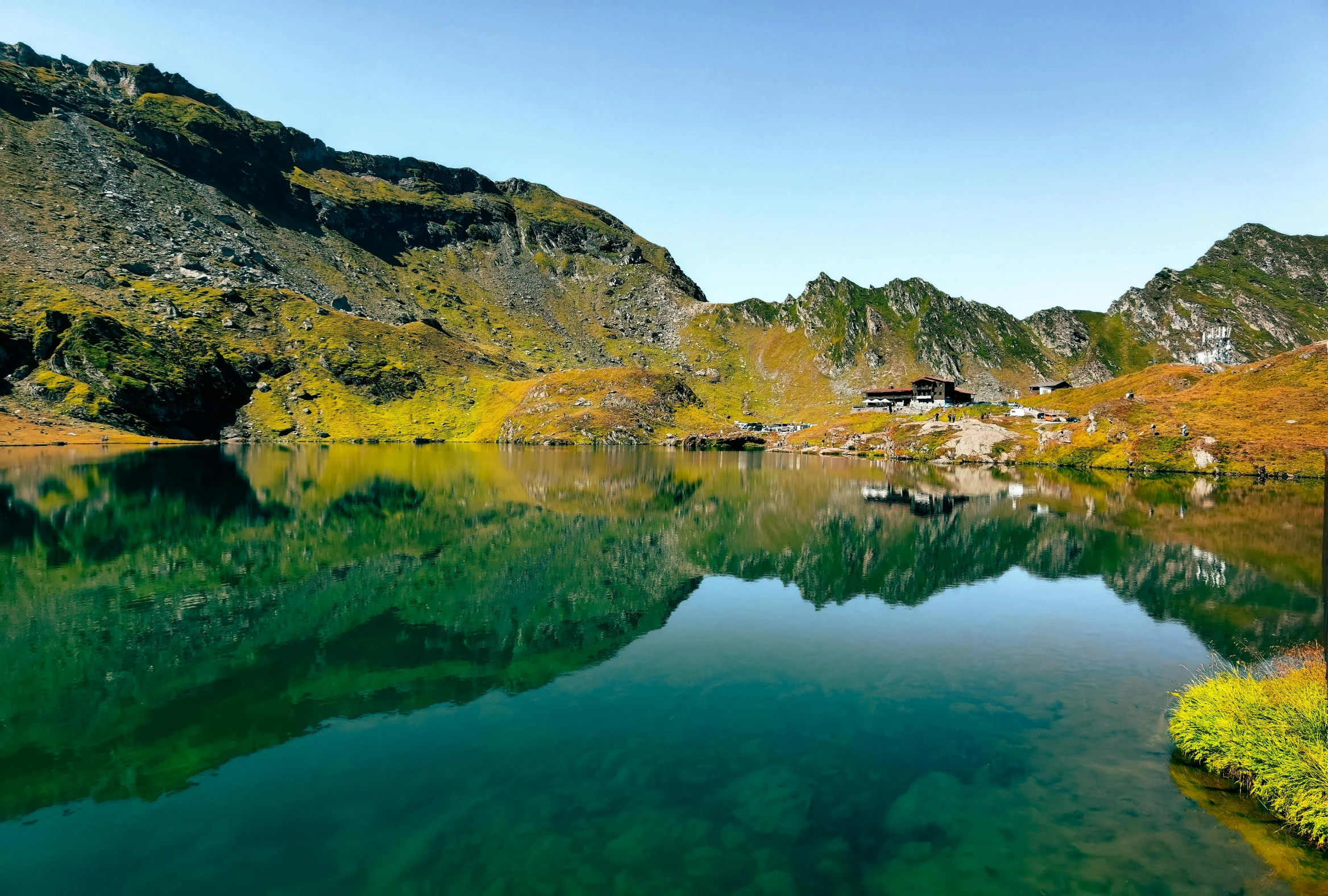 a lake surrounded by a lush green hillside