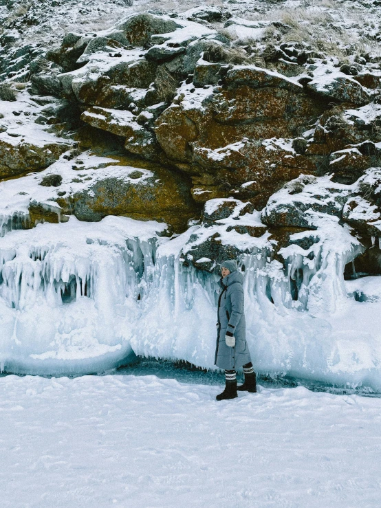 a man in the snow standing next to some ice