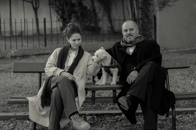 a man and woman sitting on a park bench