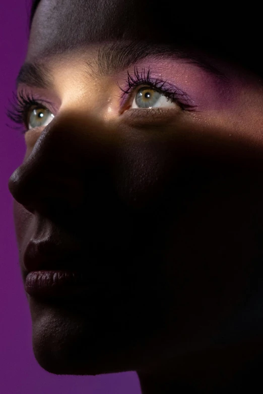 woman with blue eyes closeup on purple background