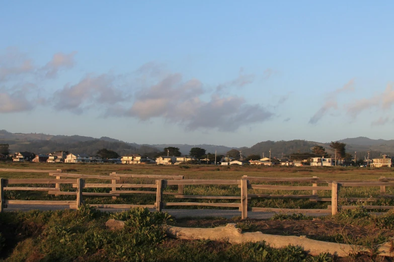 a fence surrounding a small town next to the ocean