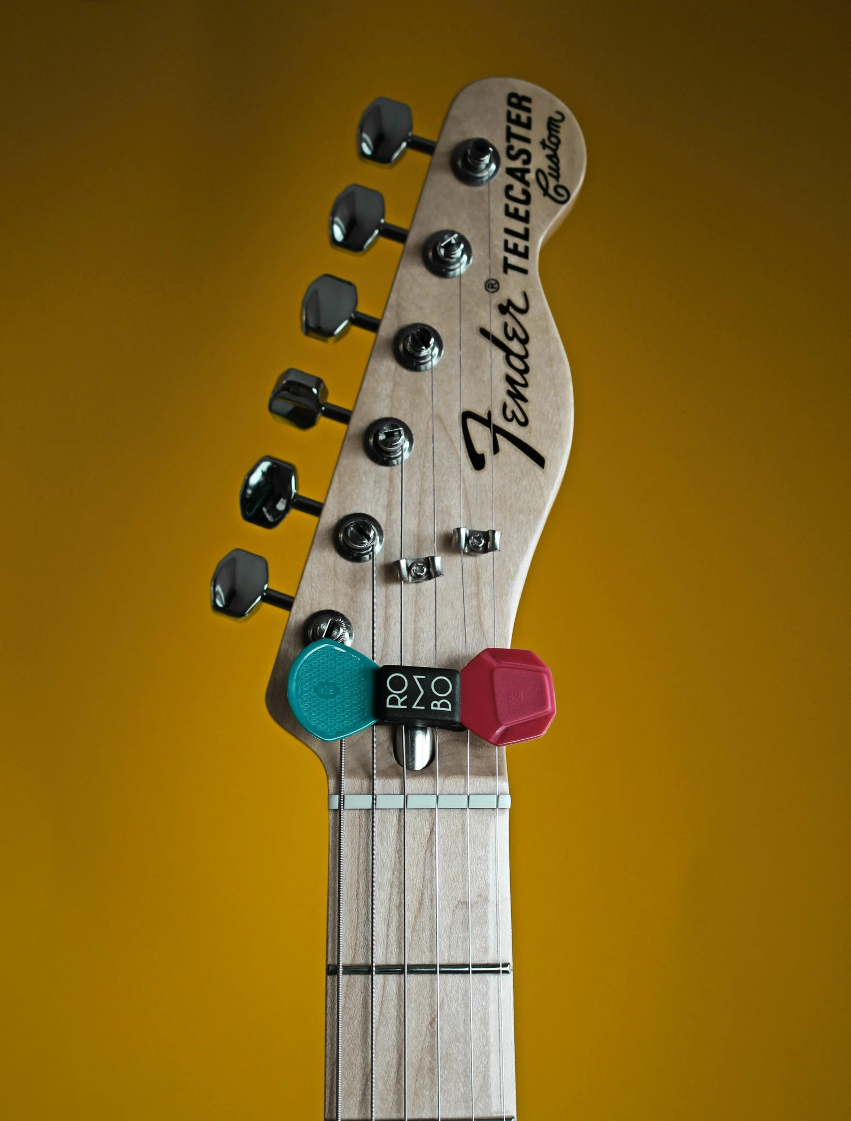 a guitar hanging on a wall with a yellow background