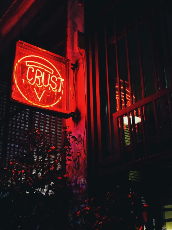 a bright red neon sign on the side of a building