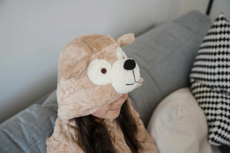 a woman with a teddy bear hat in bed
