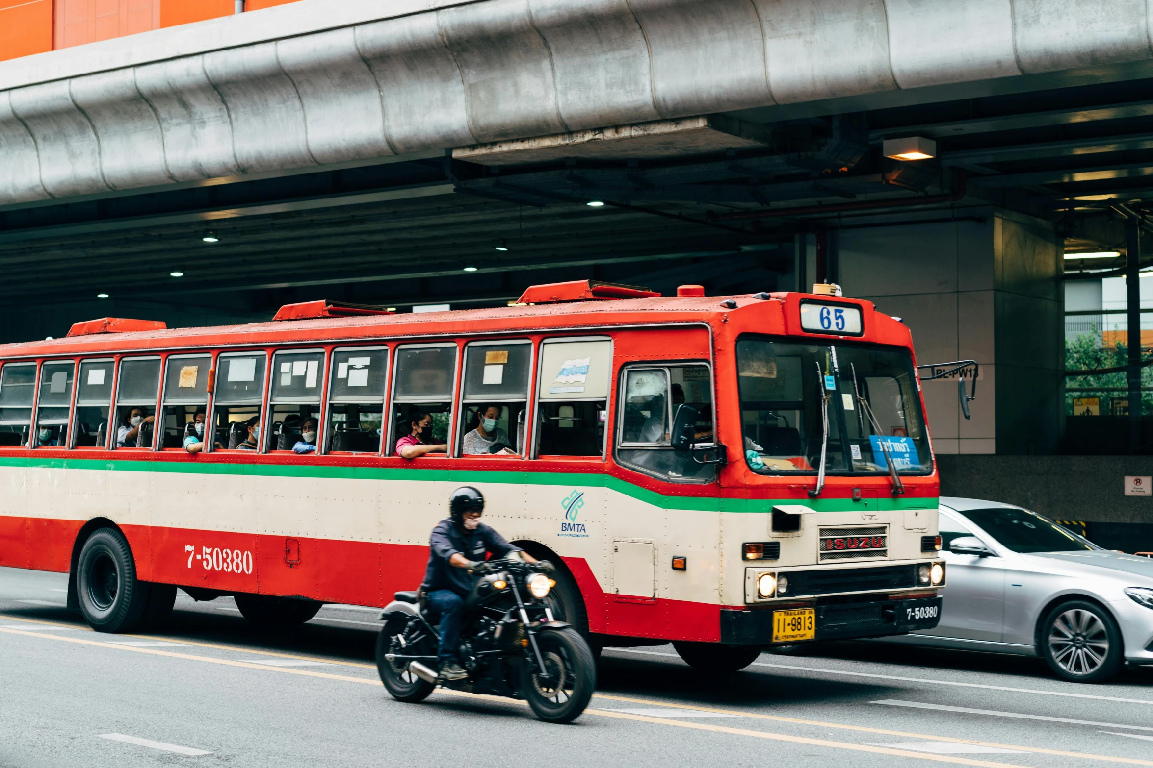 a man riding on a motorcycle next to a bus