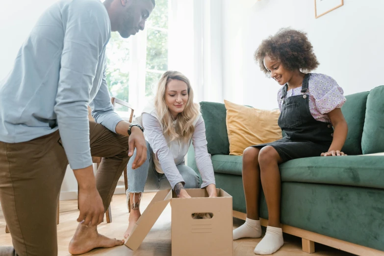 people moving boxes from couch to table