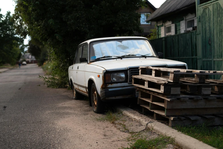 a white van sitting on the side of a road next to wooden pieces
