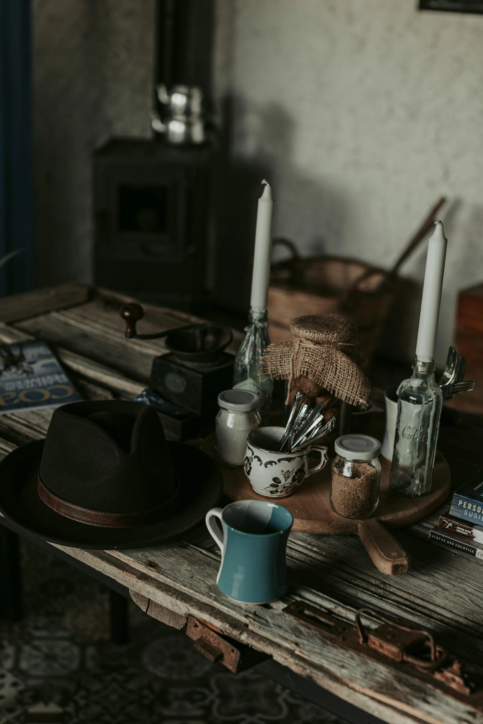 three candles are on a wooden table with various items around them