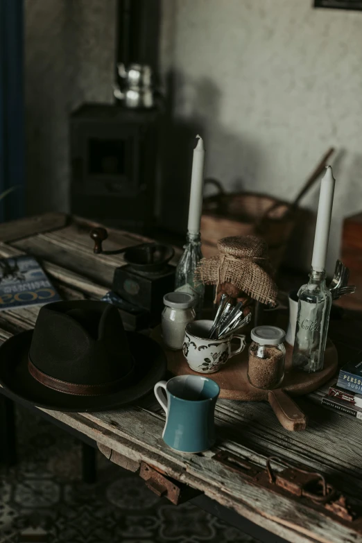 three candles are on a wooden table with various items around them