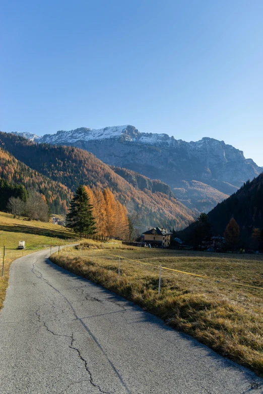 an empty road is in the middle of a grassy field