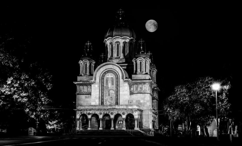 an old building with spires, steeple and clock on a dark night