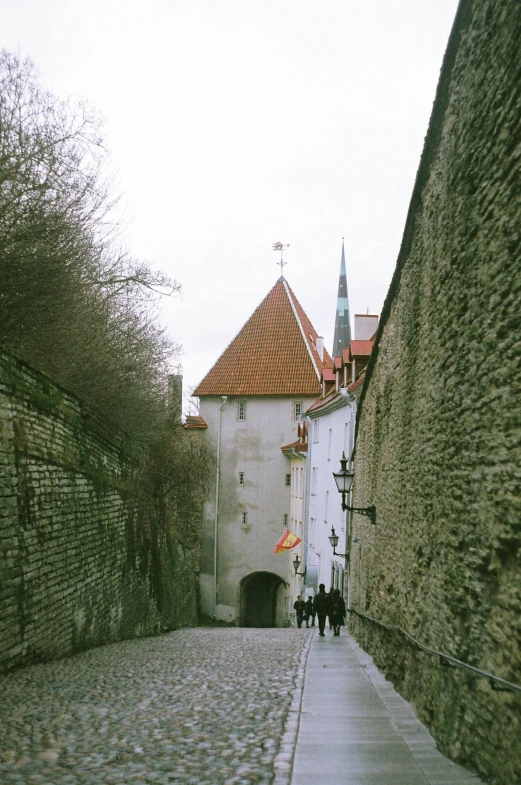 people walking along a brick road in a medieval town