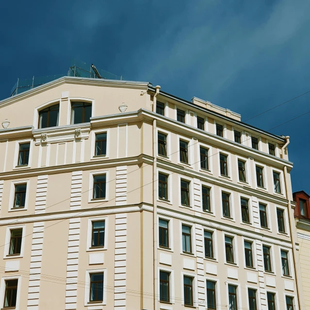 the top of a tall building with windows on a street corner