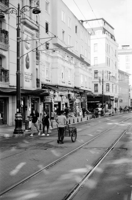 people are walking in the street with trolley cars