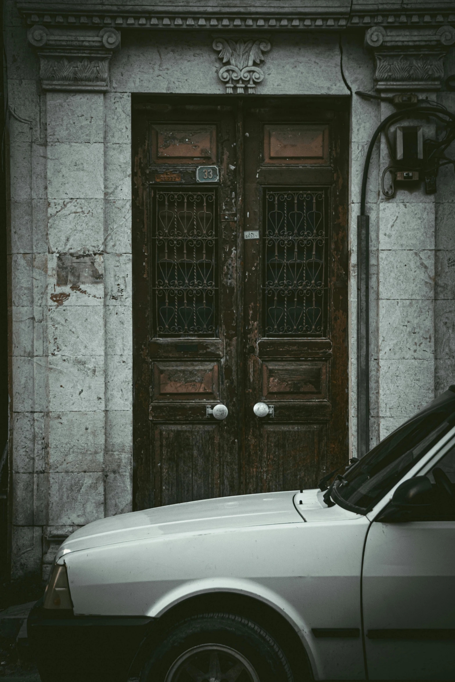 an old car sitting in front of an old door