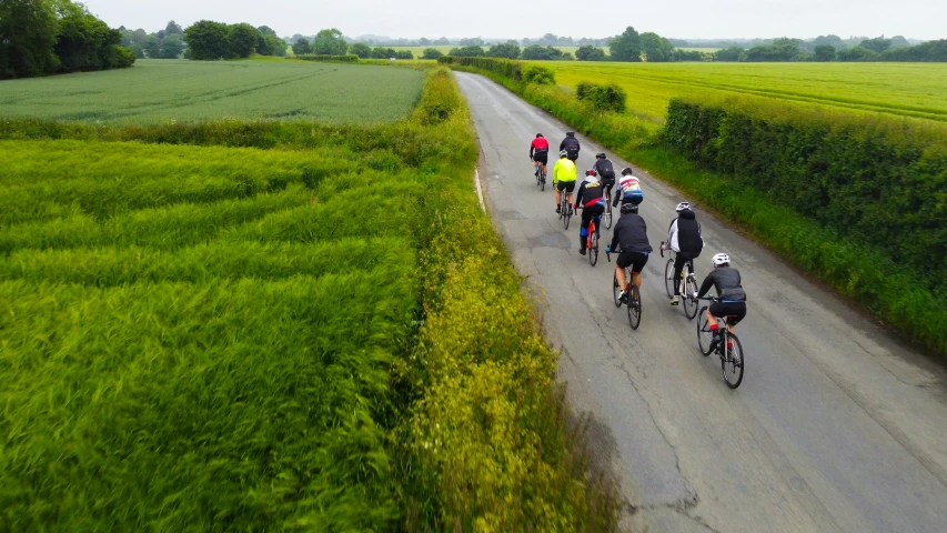 a group of people riding bicycles down a road