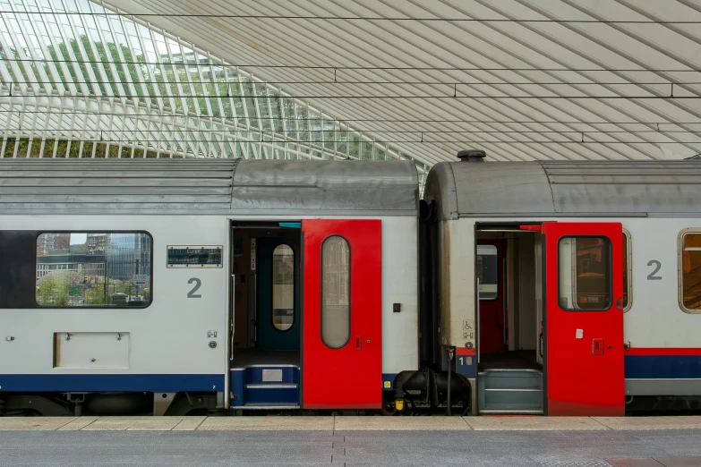 two passenger trains are stopped at a station