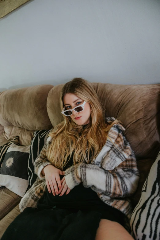 a  in black glasses sits on the couch