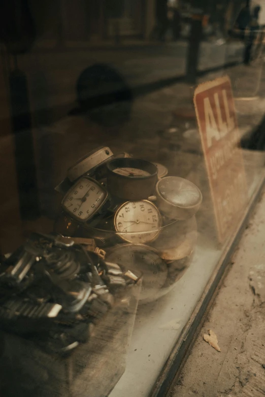 various clocks sitting on top of each other in a glass case