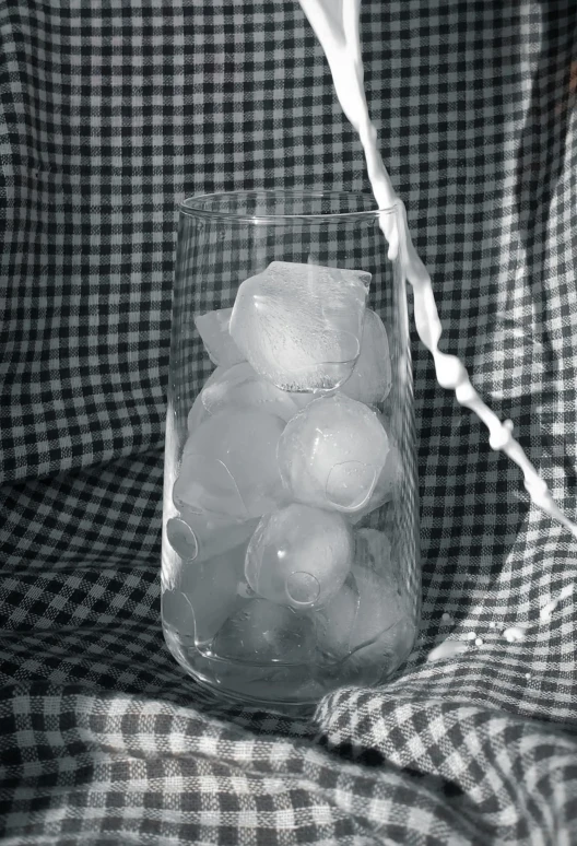 a glass of ice is filled with water and water droplets