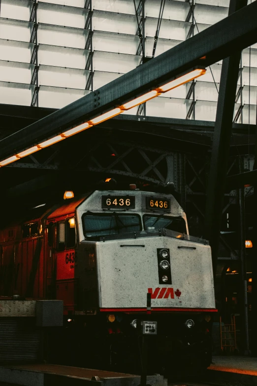 a train station with a silver train under some lights