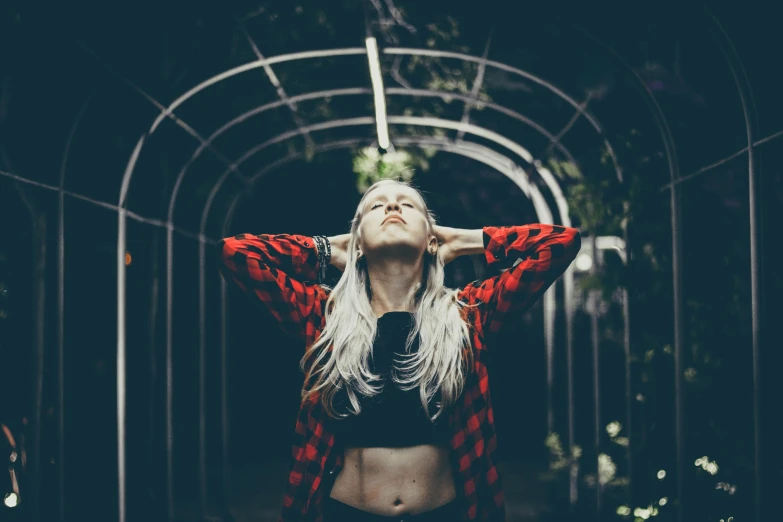 woman with blonde hair and a red jacket holding her hands in the air