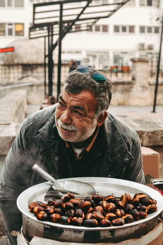 a man with glasses on, a plate of nuts, and a beer