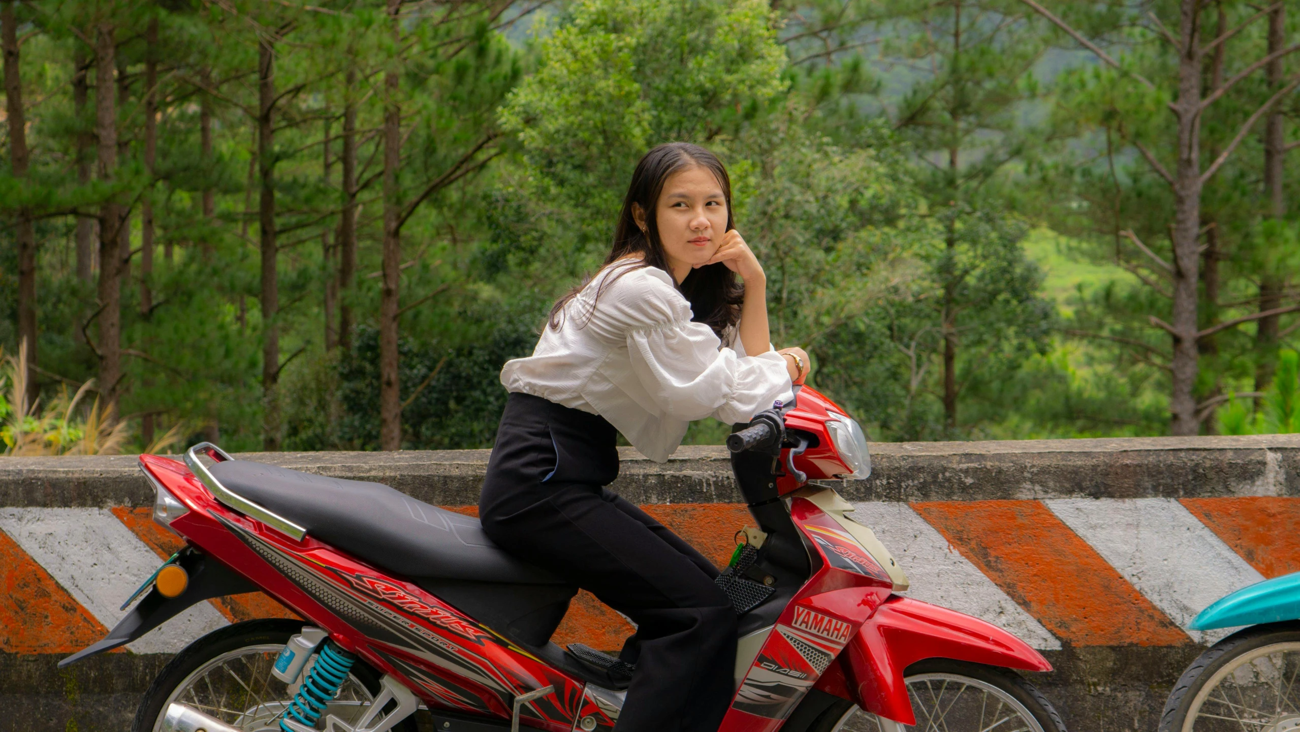 a  sitting on top of a red motorbike