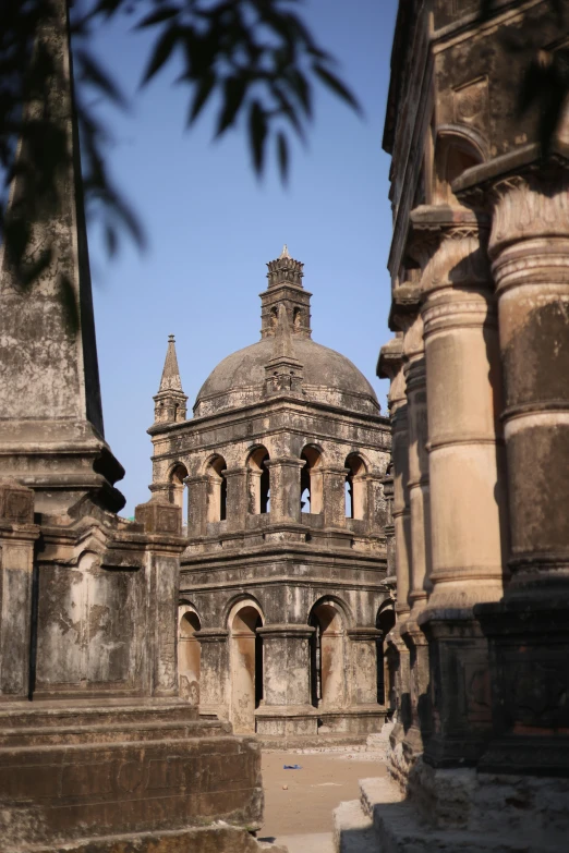 an ancient building is next to steps with a tree