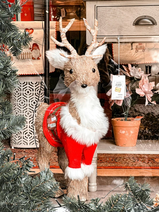 a stuffed reindeer with a santa claus outfit on