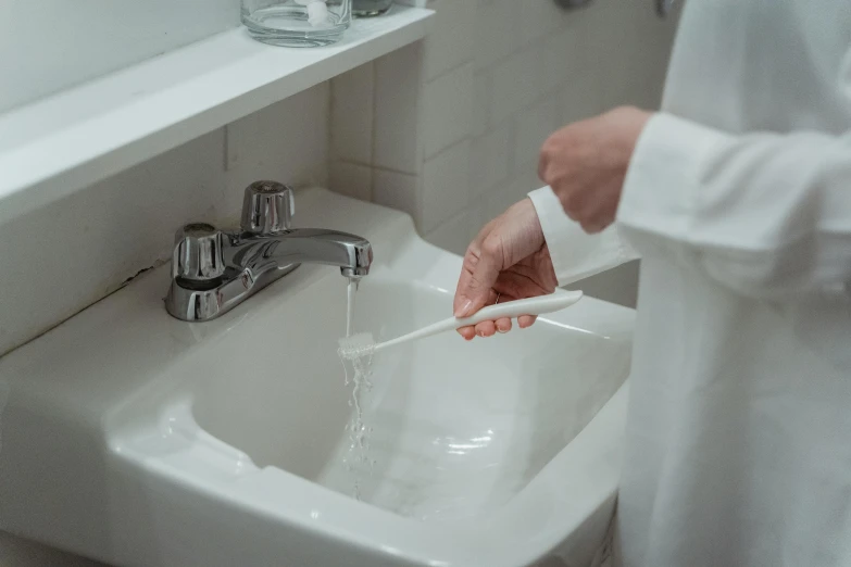 a close up of a person brushing their hands in the bathroom