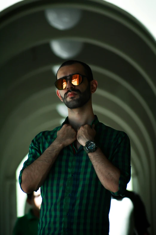 a man with sunglasses that is wearing green