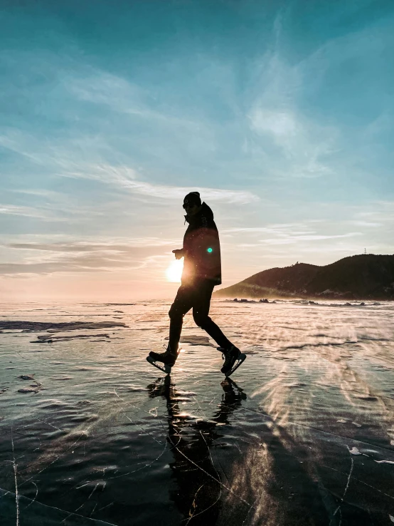 a man that is standing in the water near some ice