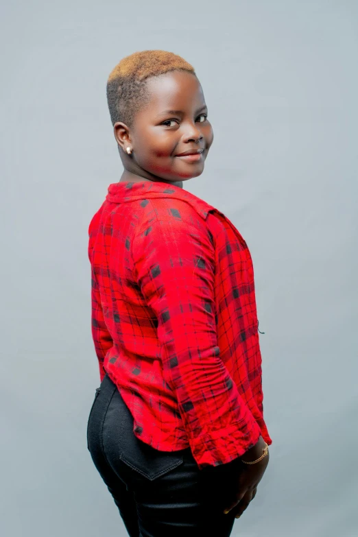 an african girl is posing with her hands in her pockets