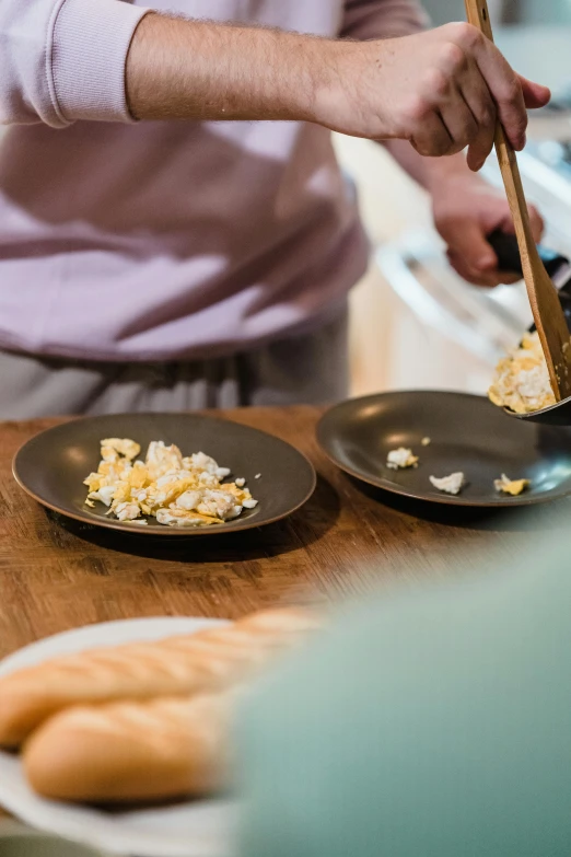 a man using a spoon to serve corned potatoes