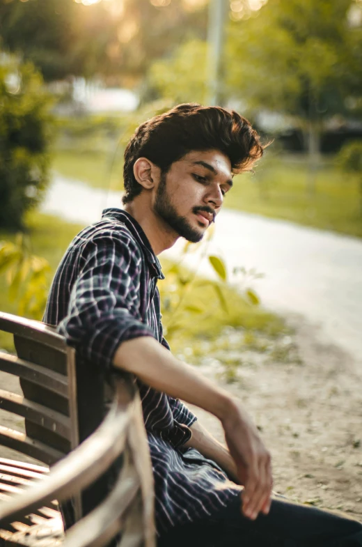 a man sitting on top of a wooden park bench