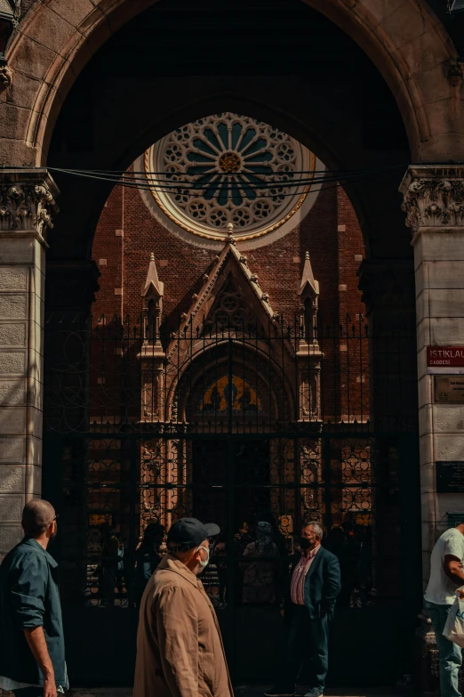 group of men outside a building with an arch above the doorway