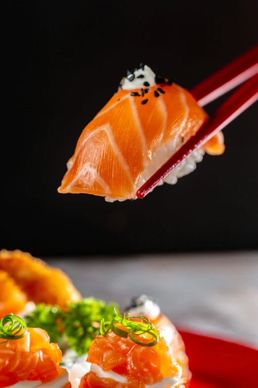 there is a red plate with food on it and chopsticks