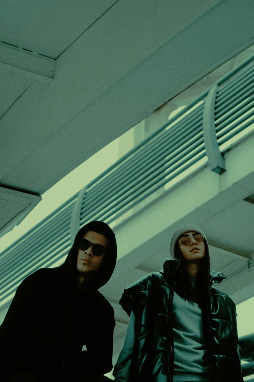 two people that are wearing sun glasses and hoods