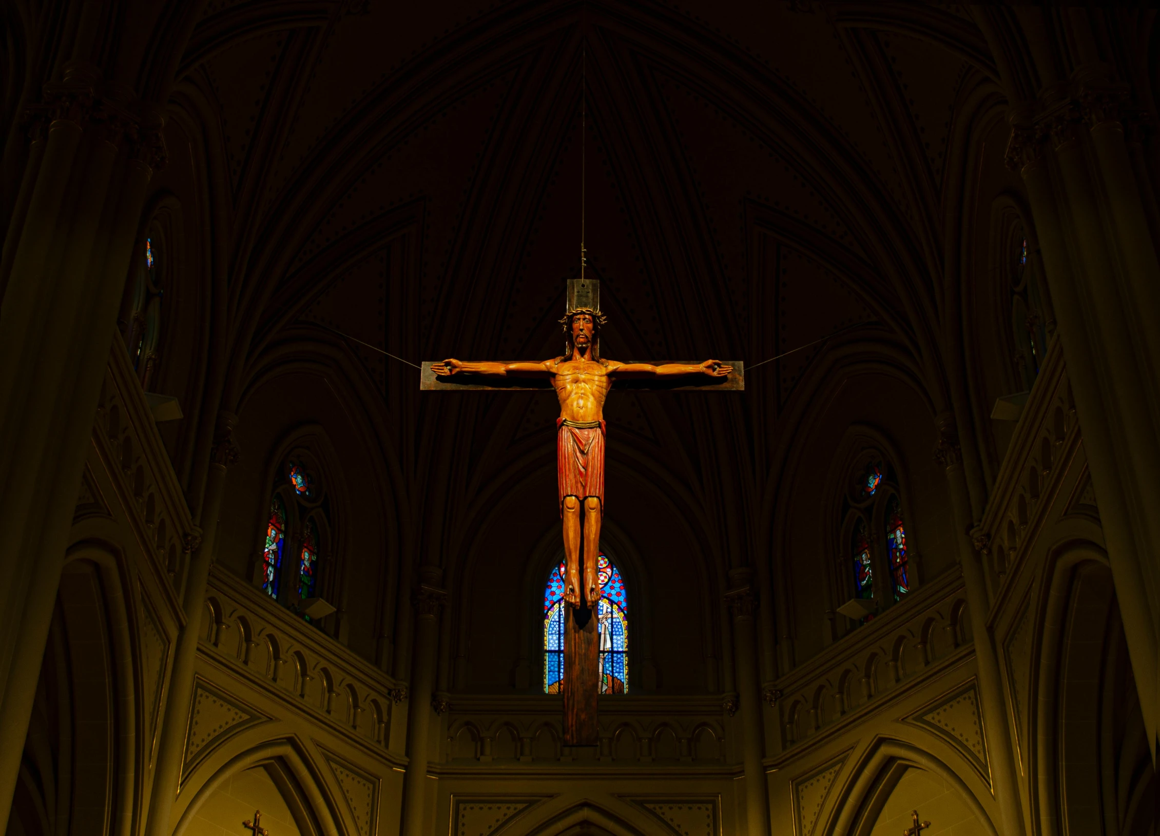 a crucifix on the wall of an interior cathedral