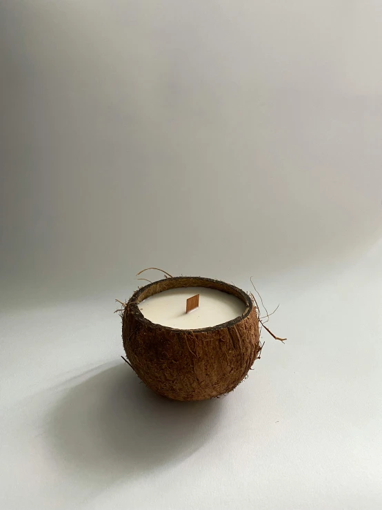 a candle with the lid open on a white table