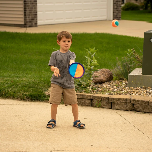 the little boy is practicing his swing at a tennis ball