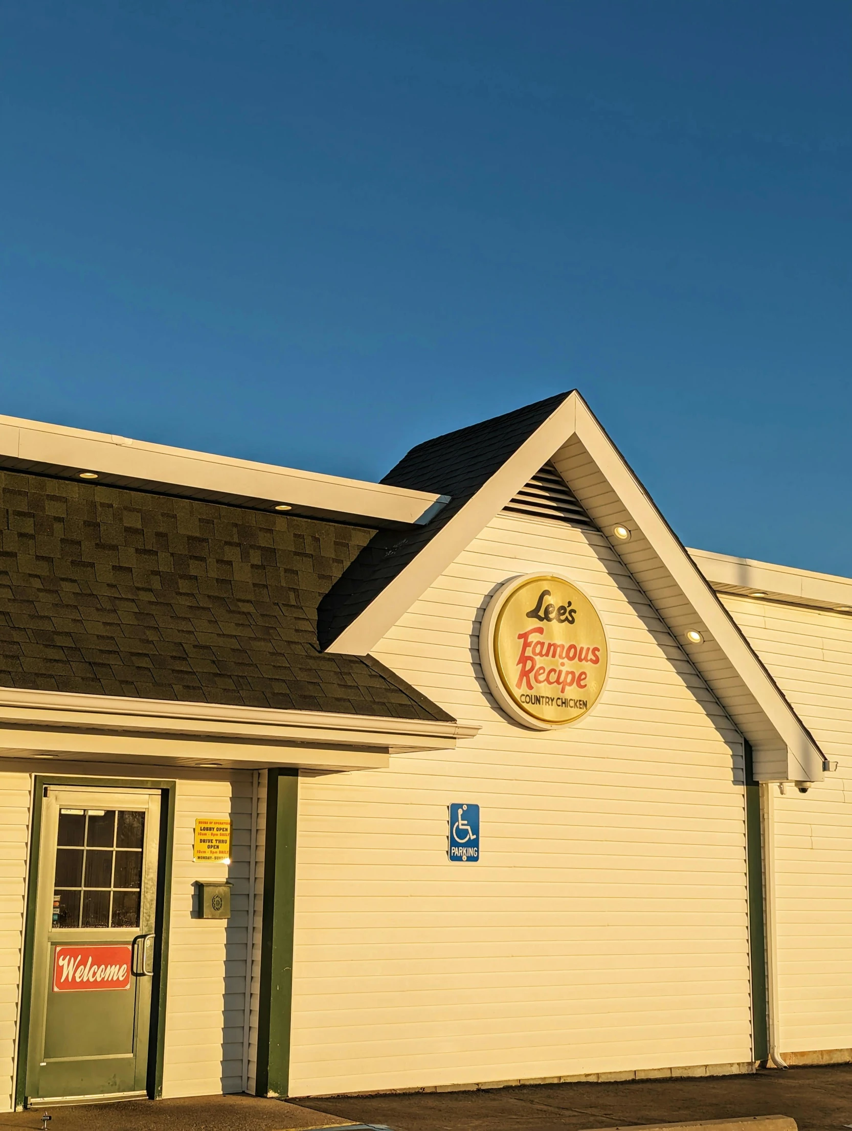 a closed yellow building with a sign for a chicken company