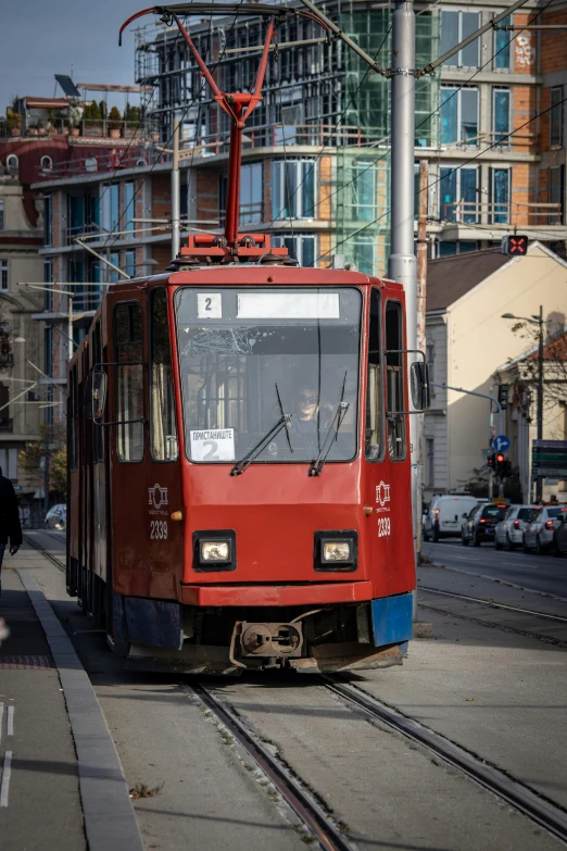 there is a red and blue trolley on the tracks