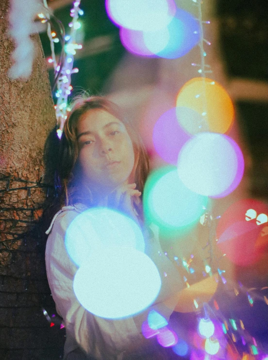 a woman standing in front of multi colored lights