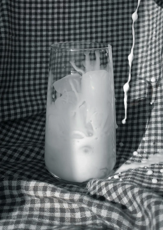 a glass filled with ice cream on top of a checkered couch