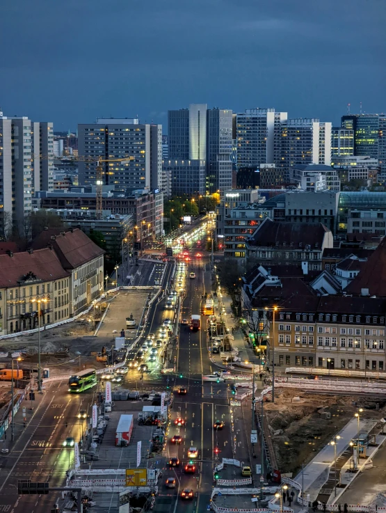 an urban street with multiple lights and traffic at night