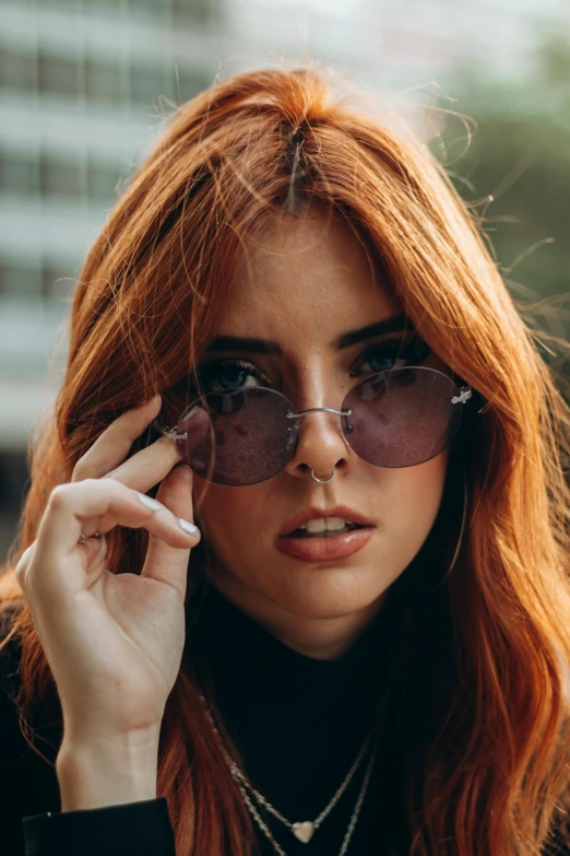 a woman with red hair and large sunglasses