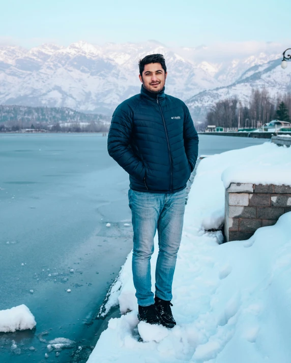 a man standing on the edge of a snowy river