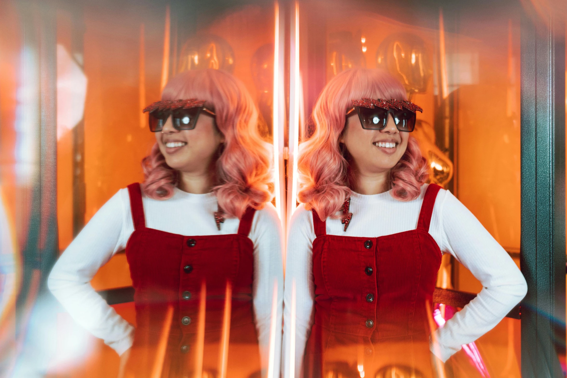 a woman with pink hair and sunglasses standing in front of a window